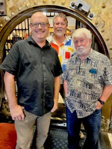 (left to right), Rob, Steve and me, posed in front of the “vault” at Belleville Books, reminiscent of the bookstore’s previous life as a bank.
